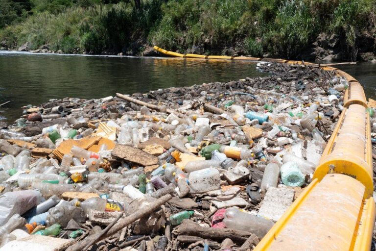 lixo em rio contido por barreira-min
